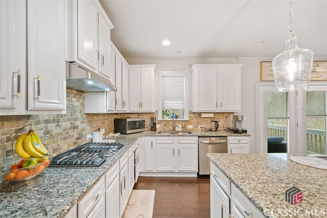 kitchen with white cabinetry, stainless steel appliances, decorative light fixtures, sink, and backsplash