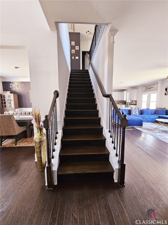 stairway featuring a chandelier and wood-type flooring