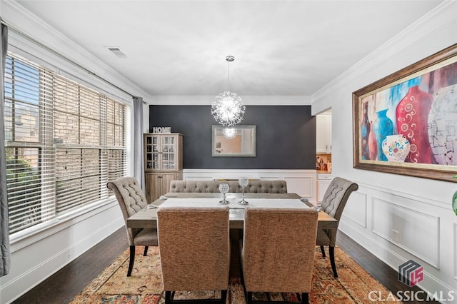 dining space featuring ornamental molding, an inviting chandelier, and dark hardwood / wood-style flooring