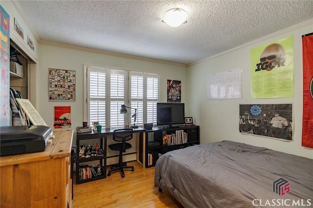 bedroom with ornamental molding, light hardwood / wood-style floors, and a textured ceiling