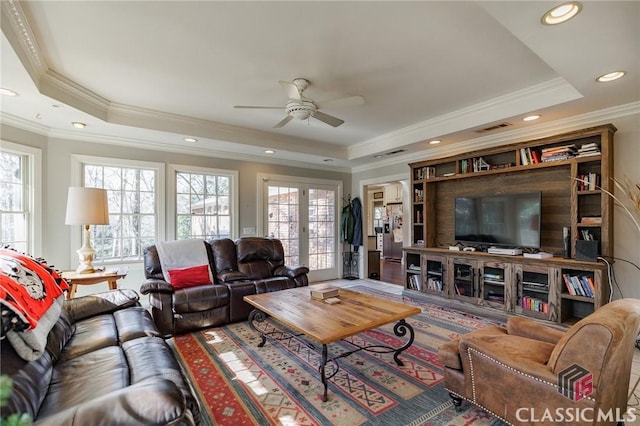 living room featuring a tray ceiling and ceiling fan