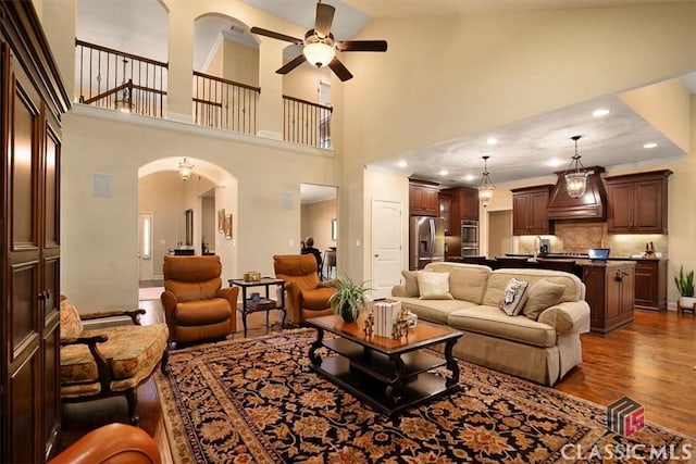 living room featuring ceiling fan, dark hardwood / wood-style floors, and sink