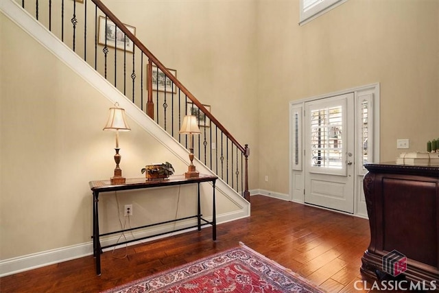 foyer with dark hardwood / wood-style floors and a high ceiling