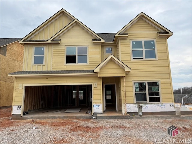 view of front of house featuring a shingled roof, board and batten siding, and an attached garage