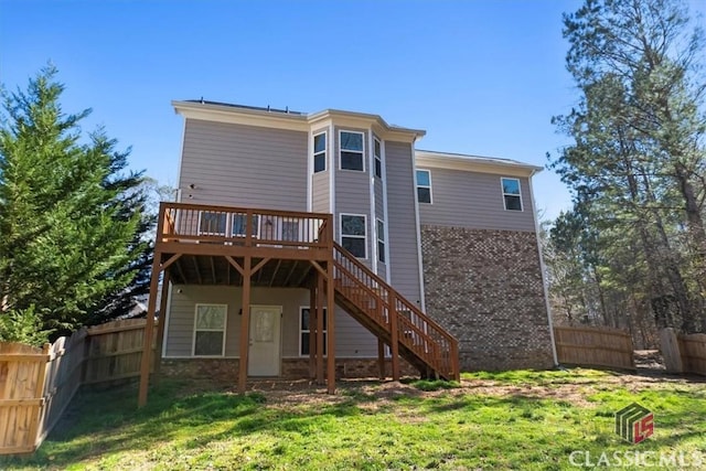 rear view of house with a wooden deck, stairway, a fenced backyard, and a lawn