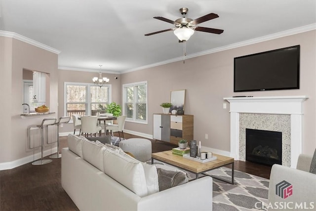 living room with baseboards, ornamental molding, and dark wood finished floors