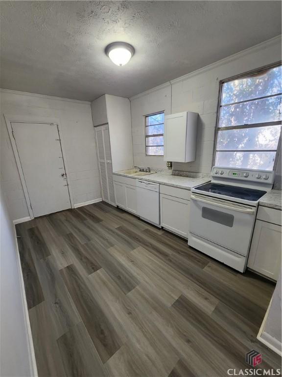 kitchen featuring white cabinetry, white appliances, dark hardwood / wood-style floors, and a textured ceiling