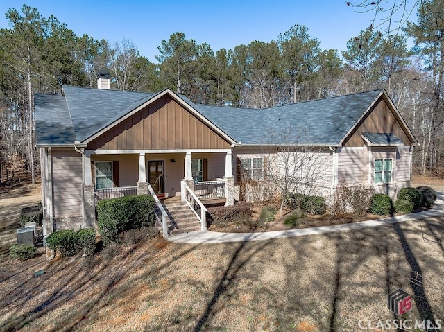 view of front of home featuring a chimney, a porch, and board and batten siding