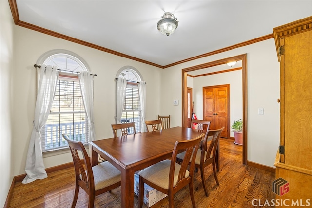 dining area featuring ornamental molding and dark hardwood / wood-style flooring