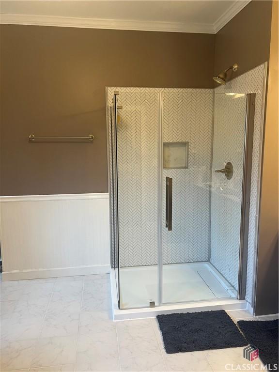 bathroom with ornamental molding and walk in shower