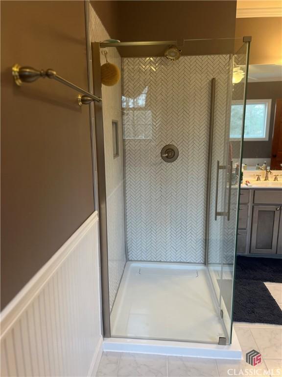 bathroom featuring ornamental molding, vanity, and a shower with shower door