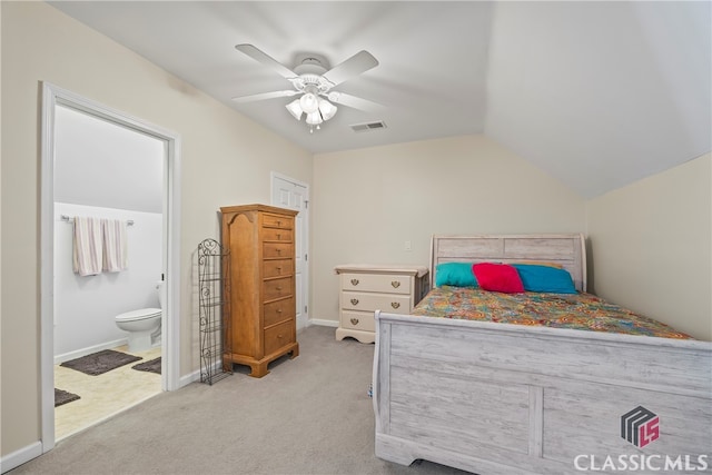 bedroom featuring ceiling fan, light colored carpet, lofted ceiling, and ensuite bathroom