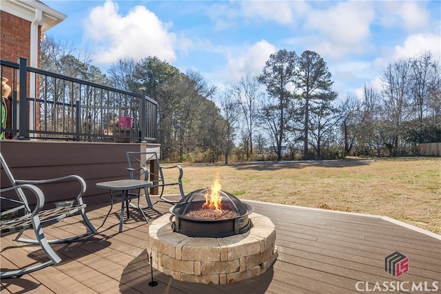 wooden deck featuring a yard and an outdoor fire pit