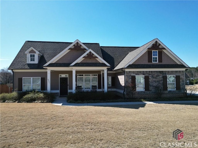 craftsman inspired home featuring a front lawn and a porch