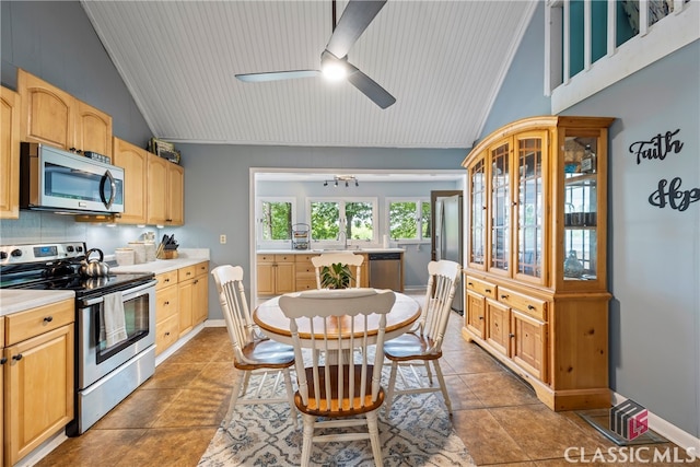 kitchen featuring vaulted ceiling, appliances with stainless steel finishes, sink, backsplash, and light brown cabinets