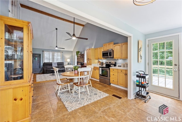 kitchen featuring light tile patterned flooring, light brown cabinetry, ceiling fan, stainless steel appliances, and beam ceiling