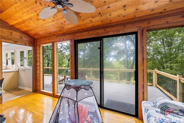 sunroom / solarium with wood ceiling, vaulted ceiling, and ceiling fan