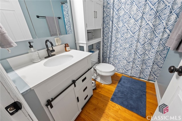 bathroom with vanity, toilet, and hardwood / wood-style floors