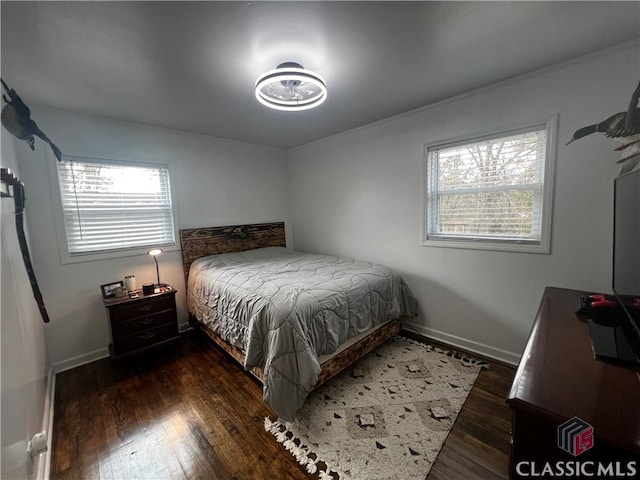 bedroom with multiple windows and dark hardwood / wood-style flooring