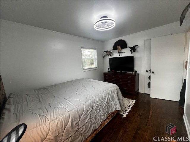 bedroom featuring crown molding and dark hardwood / wood-style floors