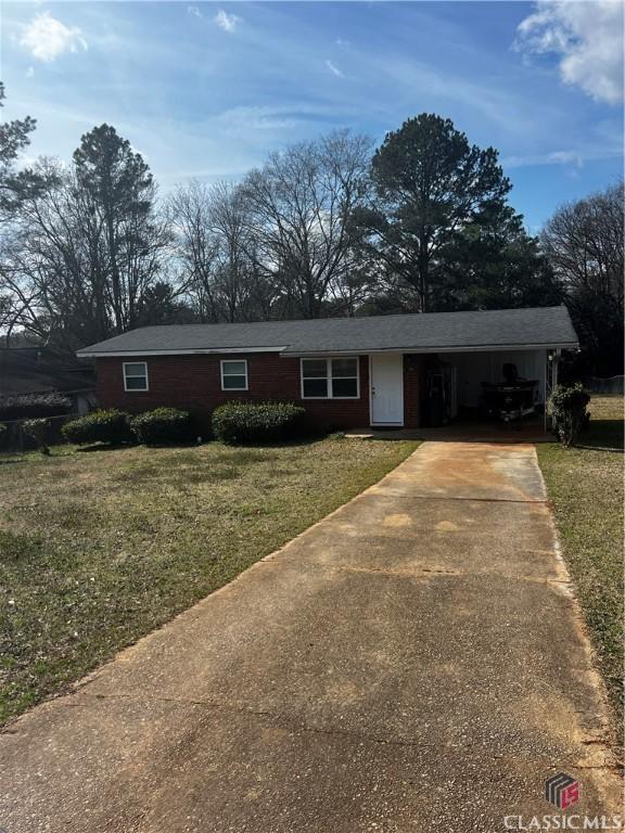 ranch-style home with a front yard and a carport