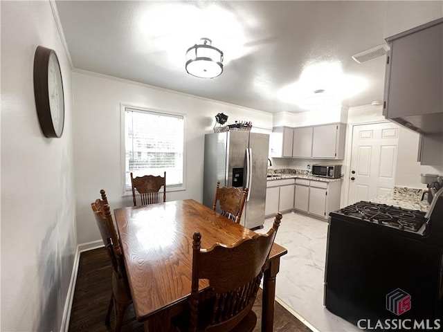 dining space featuring crown molding and sink