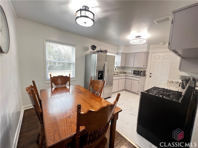 dining area featuring ornamental molding and sink