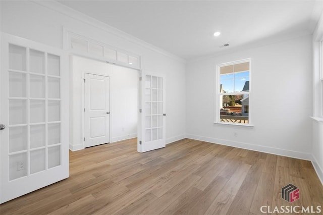 spare room with french doors, ornamental molding, and light hardwood / wood-style flooring