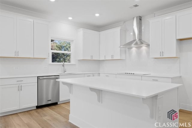 kitchen featuring a kitchen island, white cabinets, stainless steel dishwasher, wall chimney range hood, and black electric cooktop