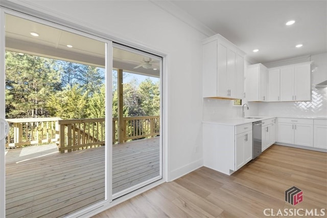 kitchen with dishwasher, sink, white cabinets, and light hardwood / wood-style floors