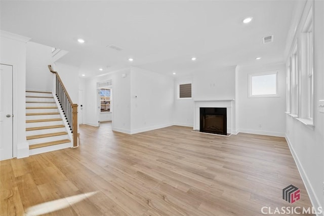 unfurnished living room featuring crown molding and light hardwood / wood-style flooring