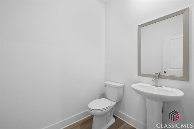 bathroom with wood-type flooring and toilet