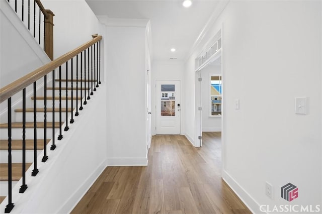 entrance foyer featuring crown molding and light hardwood / wood-style flooring