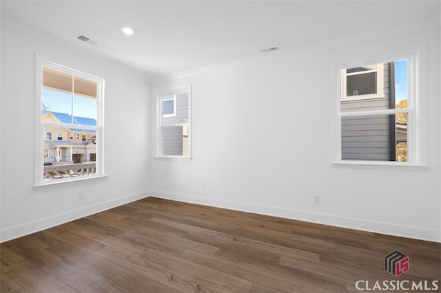 spare room featuring crown molding and dark hardwood / wood-style flooring