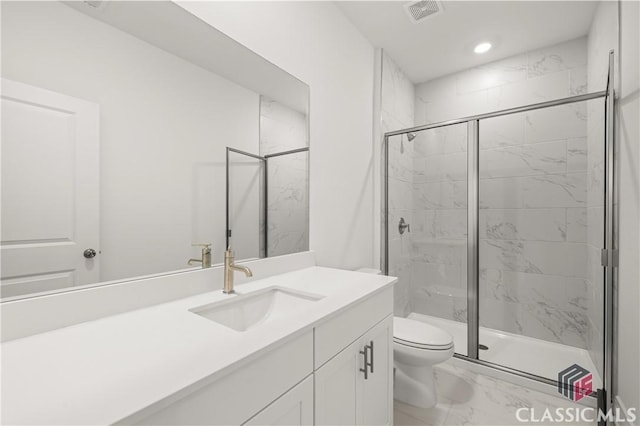 bathroom featuring vanity, a shower with door, and toilet