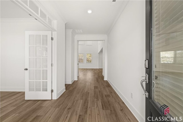 corridor featuring ornamental molding, dark hardwood / wood-style floors, and french doors