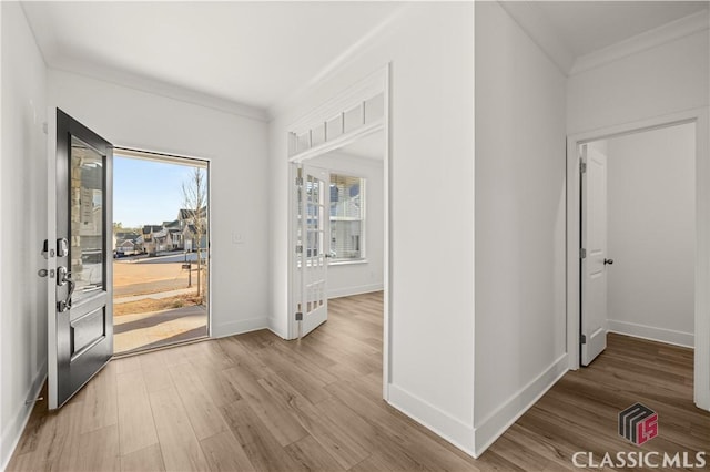 entrance foyer featuring hardwood / wood-style flooring and crown molding