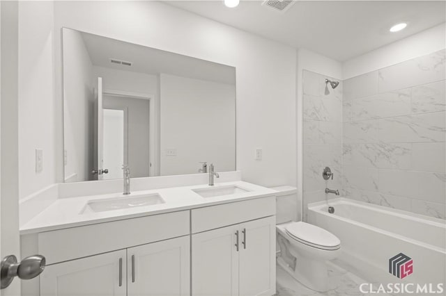 full bathroom with tiled shower / bath combo, vanity, and toilet