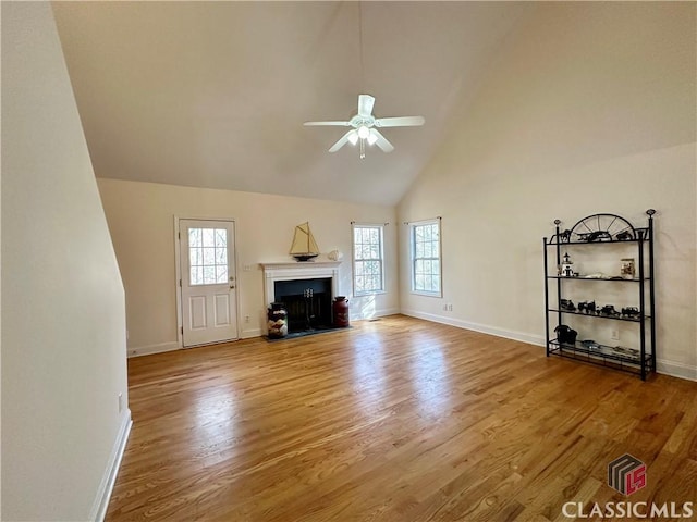 unfurnished living room with hardwood / wood-style floors, high vaulted ceiling, and ceiling fan