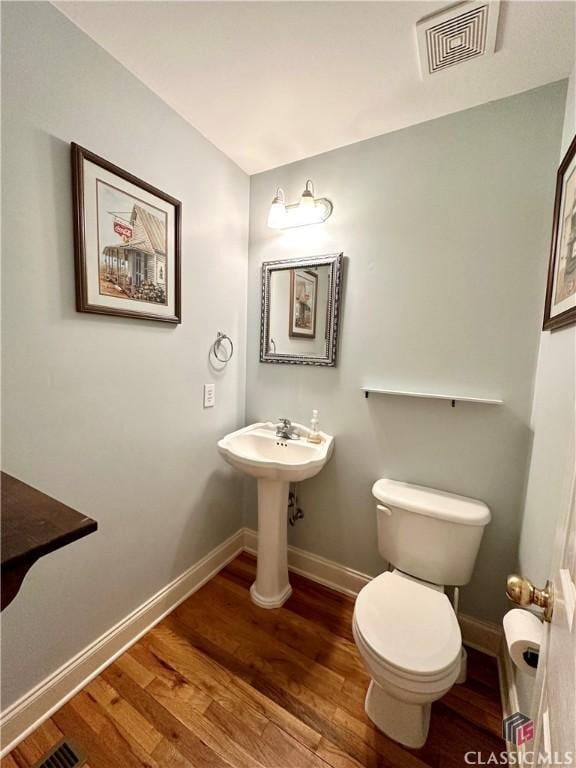 bathroom featuring hardwood / wood-style flooring and toilet