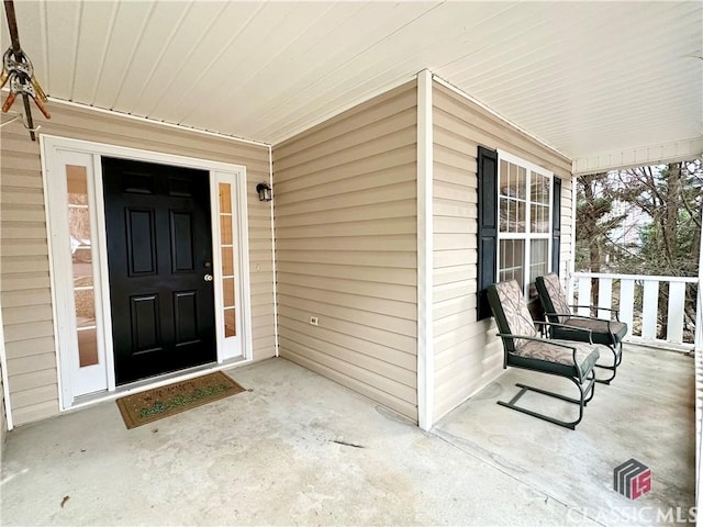 view of exterior entry featuring covered porch