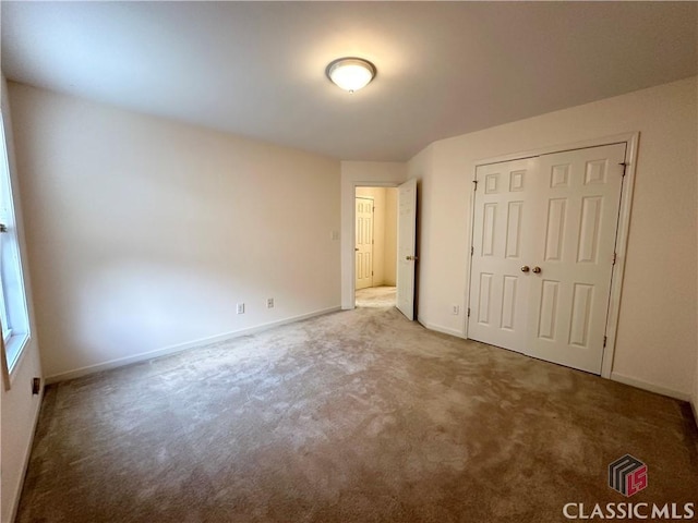 unfurnished bedroom featuring carpet floors and a closet