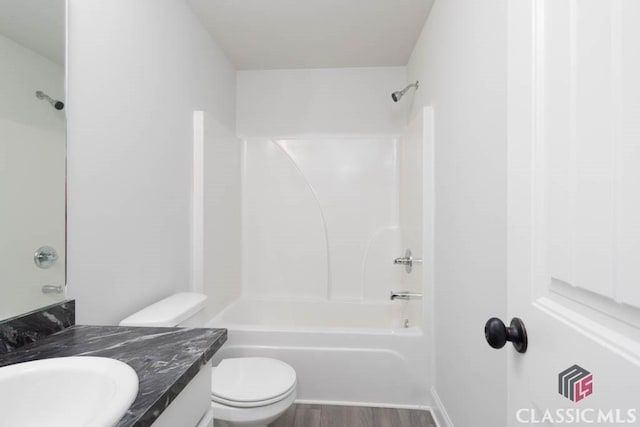 full bathroom with hardwood / wood-style flooring, vanity, toilet, and shower / washtub combination