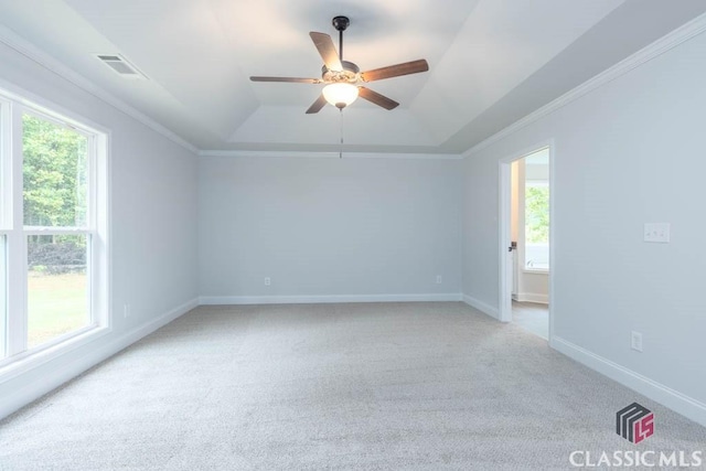 carpeted spare room with ornamental molding, ceiling fan, and a tray ceiling