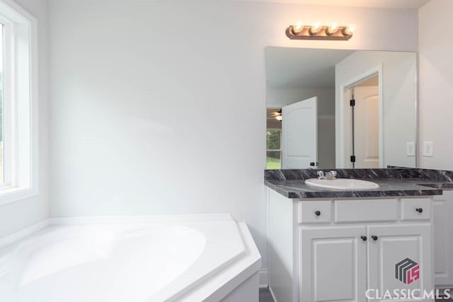 bathroom featuring vanity and a tub to relax in