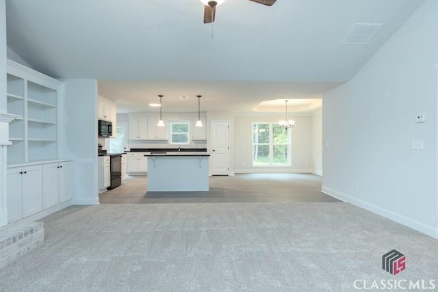 kitchen with decorative light fixtures, a center island, light carpet, range with electric cooktop, and white cabinets