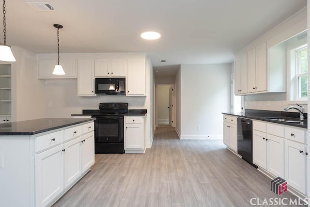 kitchen with decorative light fixtures, sink, white cabinets, and black appliances