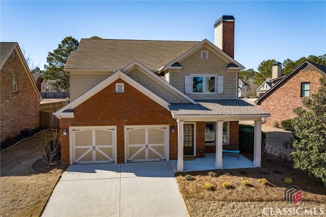 view of front facade with cooling unit, a garage, and covered porch