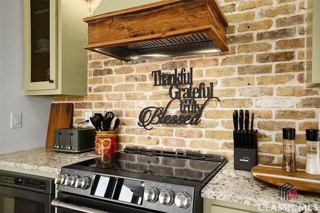 kitchen with custom exhaust hood, stainless steel electric stove, light stone counters, and green cabinetry