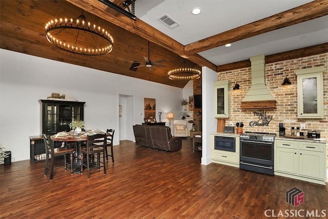 kitchen featuring stainless steel electric range oven, hardwood / wood-style floors, beamed ceiling, built in microwave, and custom range hood